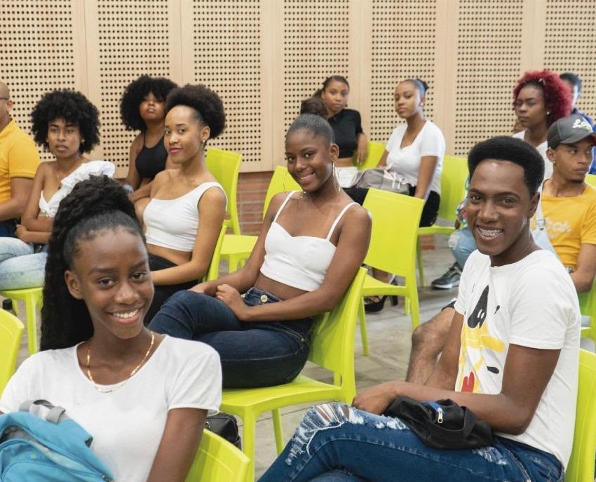 Jóvenes participantes sonriendo durante un seminario de Afrotex